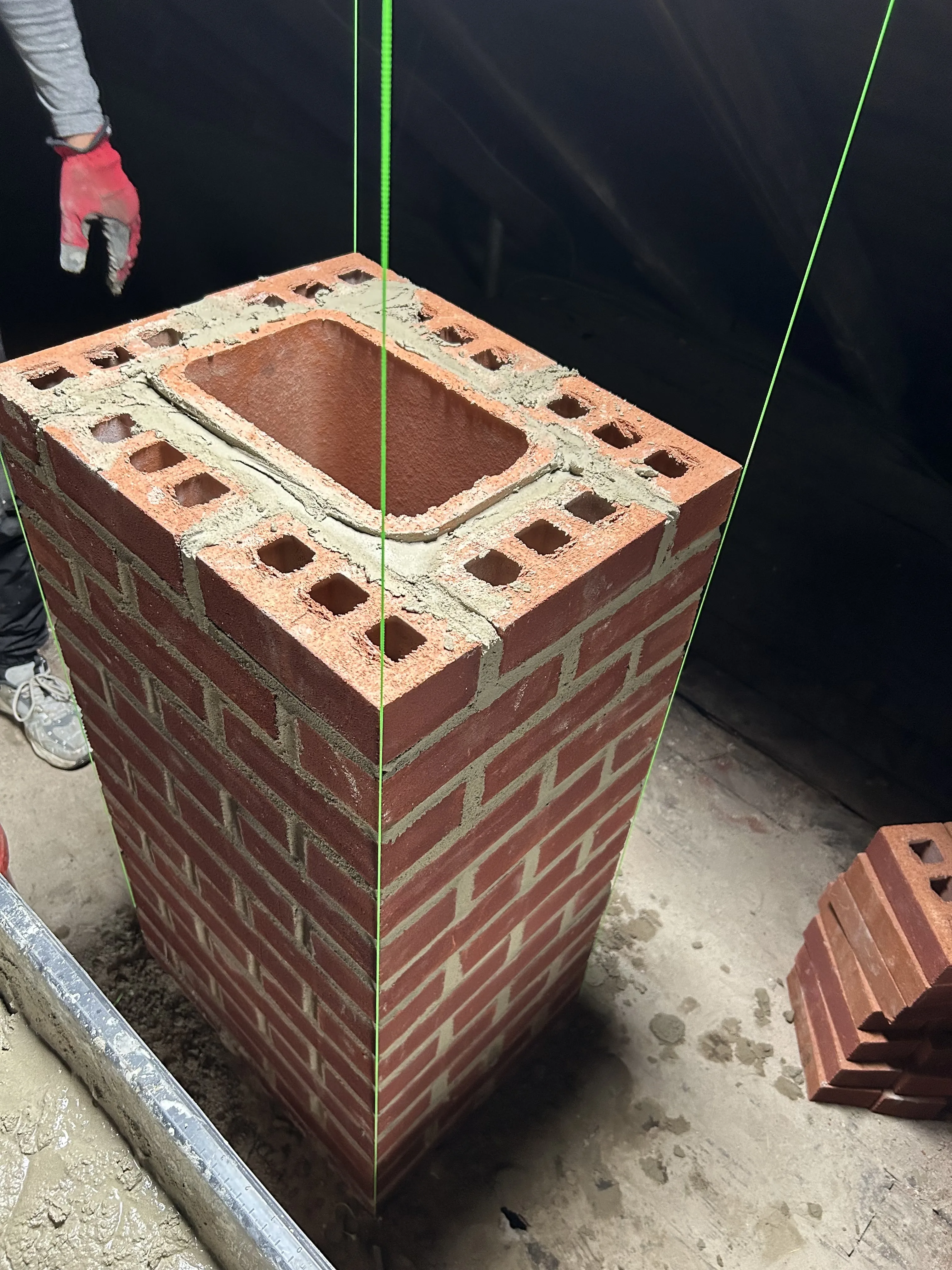 Close-up of the rebuilt brick chimney showing tight mortar joints and the mortared flue opening.