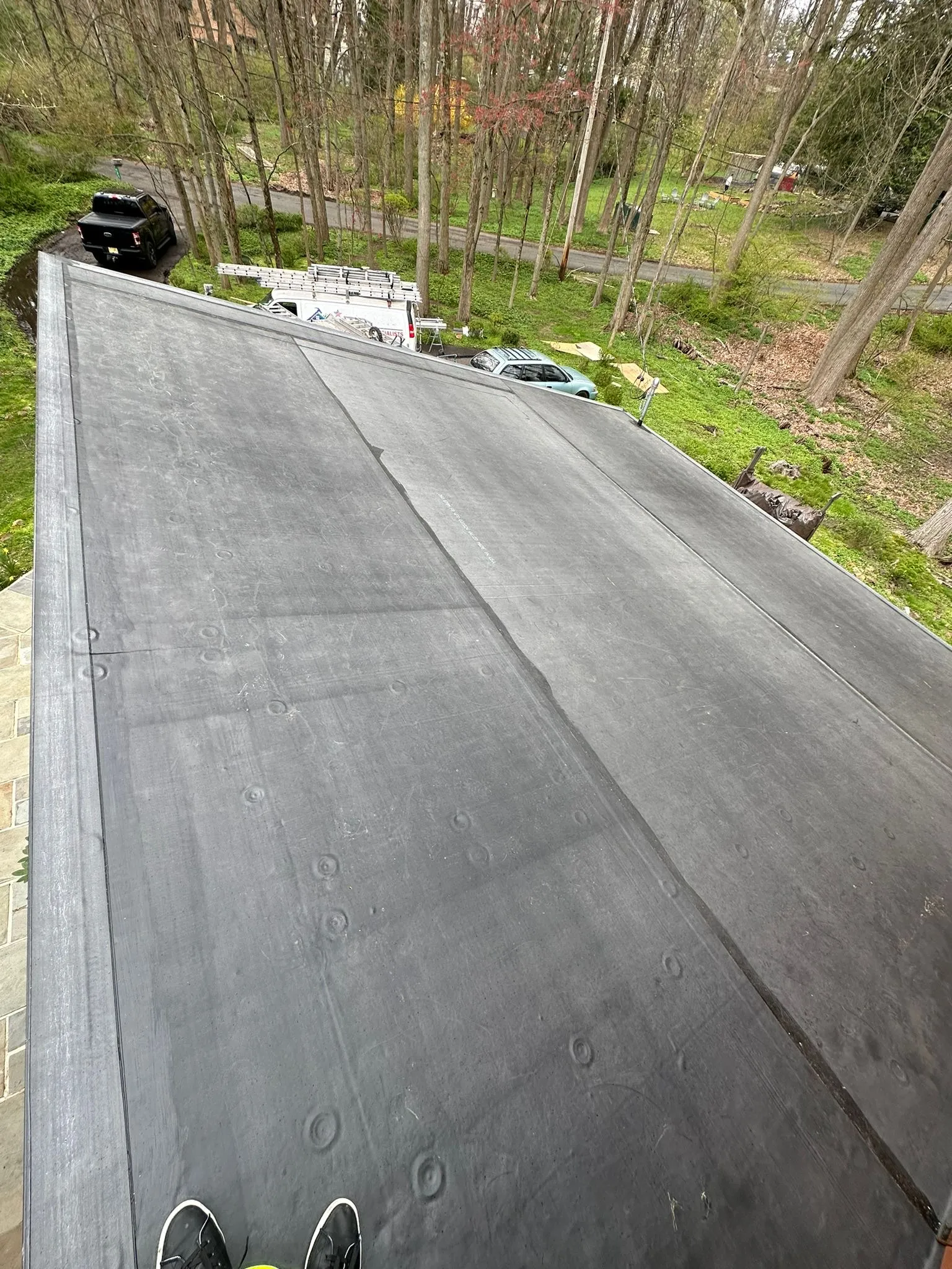 The same flat roof finished with new black EPDM membrane running clean down the slope.