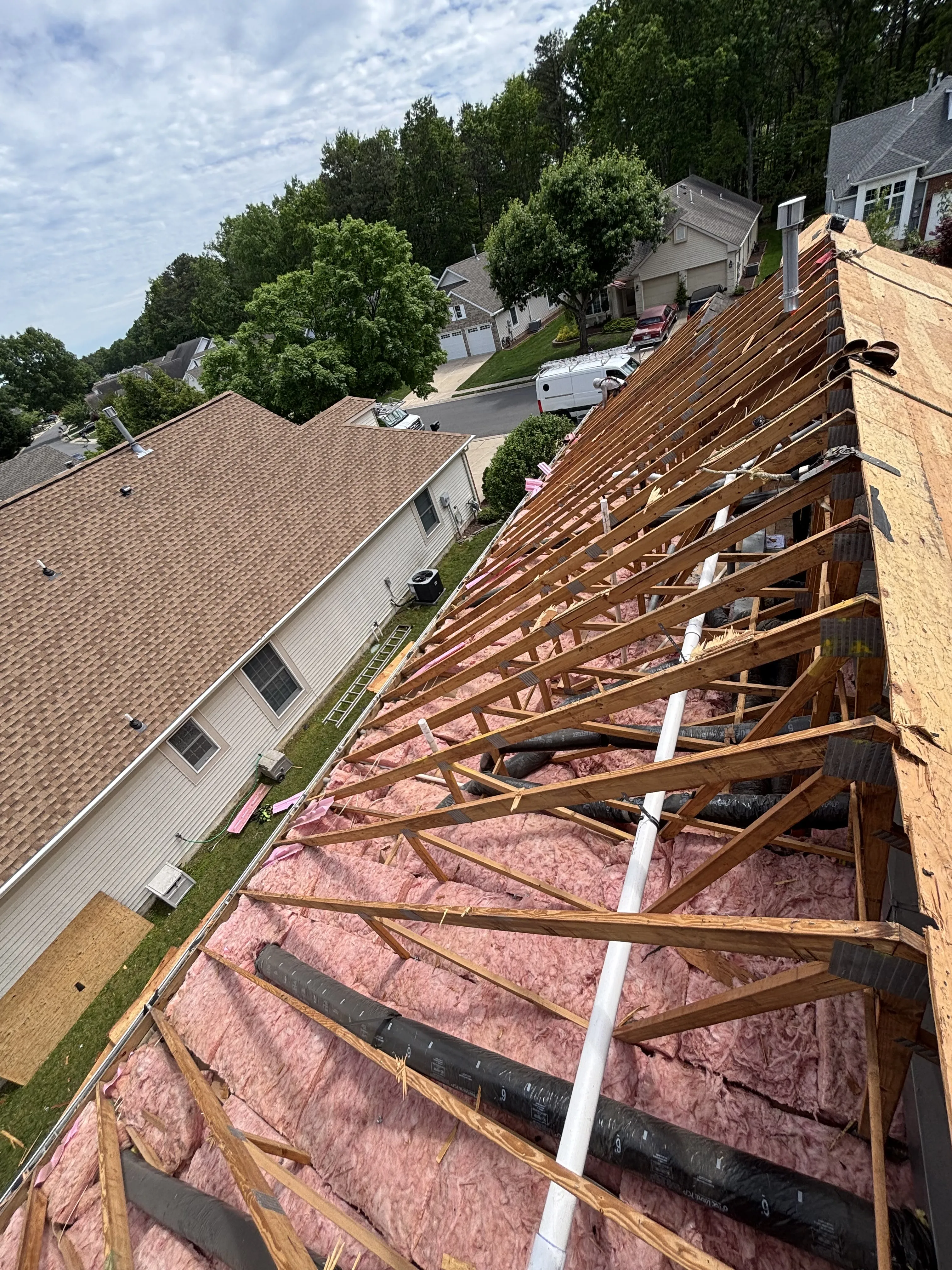 Roof structure stripped to the rafters, with the old sheathing removed ahead of the new decking install.